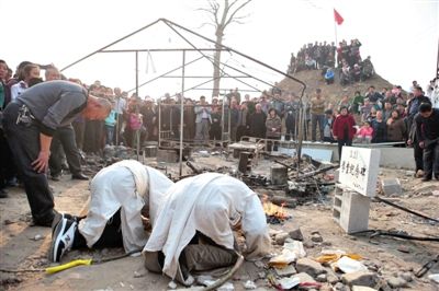  3月23日，青岛平度市杜家疃村，耿福林的出殡仪式，亲属在被烧毁的帐篷边祭拜。新京报记者 王嘉宁 摄