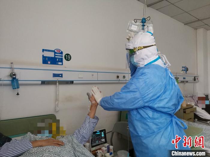 看望病人，和病人击掌。南京医科大学第二附属医院供图